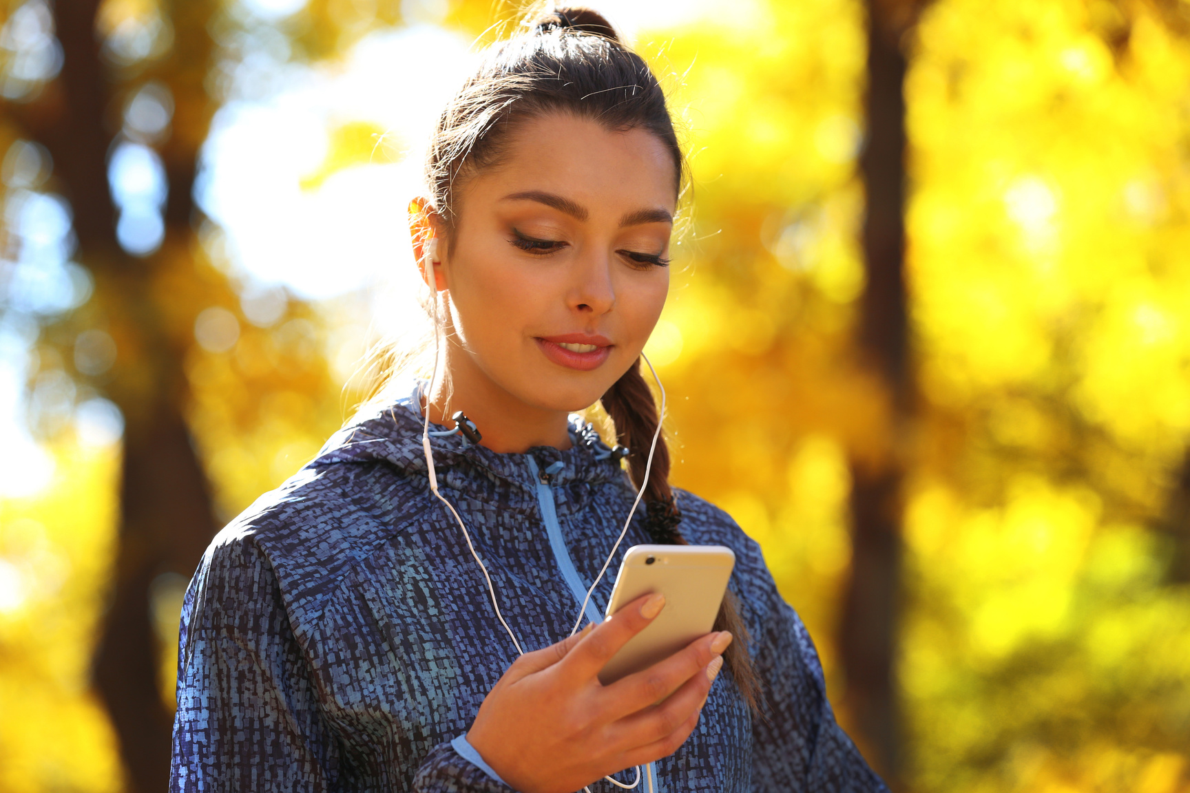 Woman Holding Phone, Listening to Music with Headphones